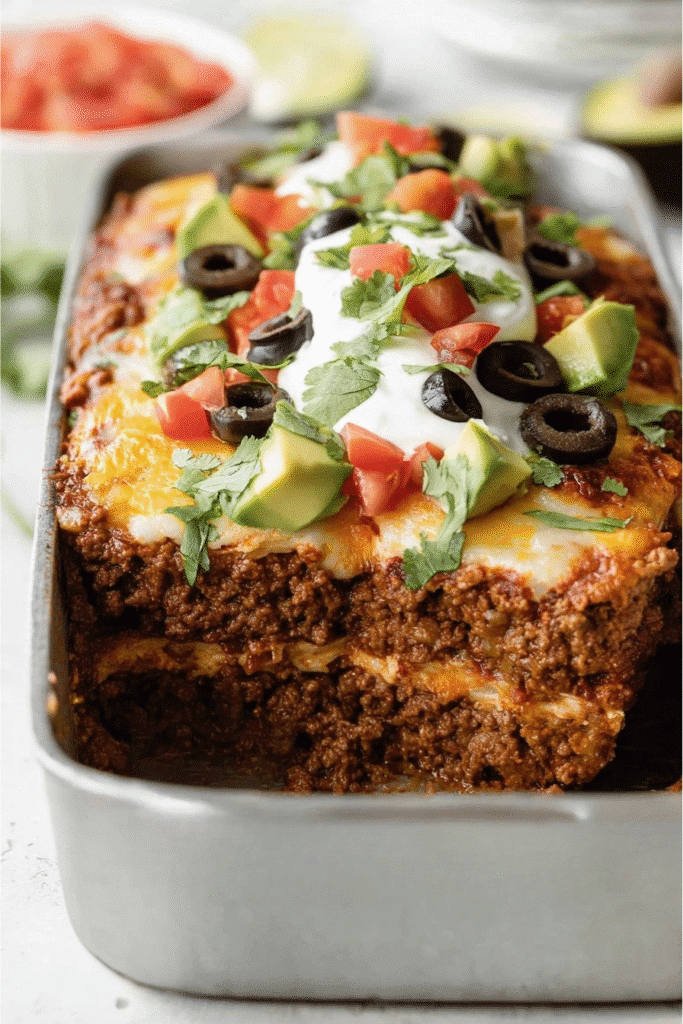 Keto Taco Lasagna: The Ultimate Crave-Worthy Low-Carb Dinner 1 Cut keto taco lasagna in a loaf pan showing layers of beef and cheese