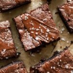 Top-down view of chocolate protein brownies with melted chocolate and sea salt