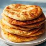 Stack of homemade keto flatbreads with golden crust on a ceramic plate