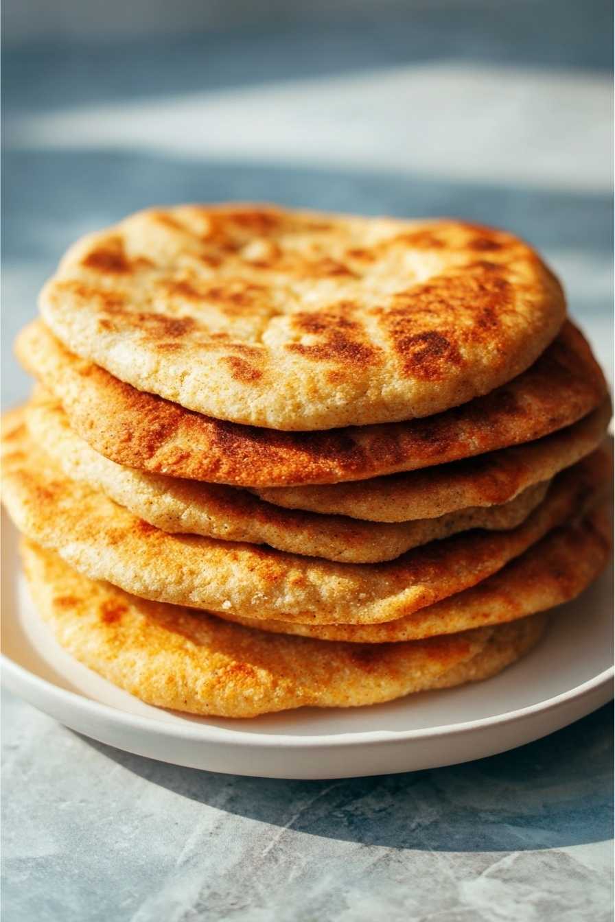 Keto Flatbread Recipe That Will Make You Forget Store-Bought Bread 2 Stack of homemade keto flatbreads with golden crust on a ceramic plate