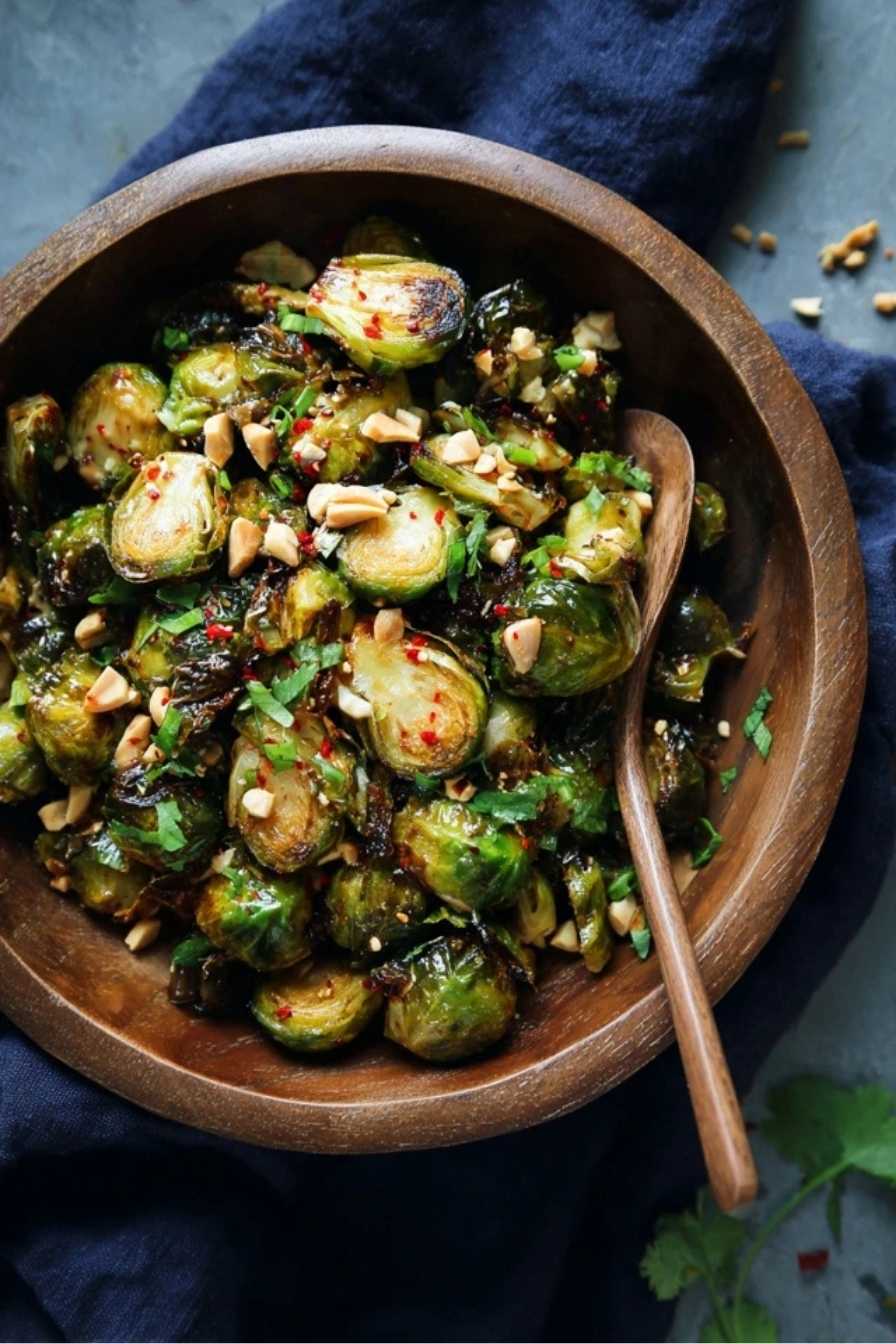 Kung Pao Brussel Sprouts – A Spicy, Crispy Twist You’ll Crave Again and Again 2 Kung Pao Brussels sprouts in a wooden bowl topped with peanuts and herbs