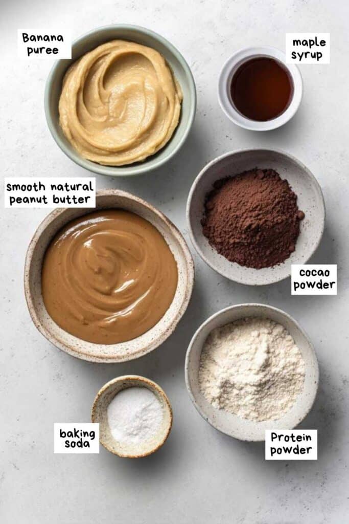 Vegan Protein Brownies – A Rich, Guilt-Free Treat You’ll Crave 3 Flat lay of vegan brownie ingredients in bowls including banana, protein powder, and cocoa.