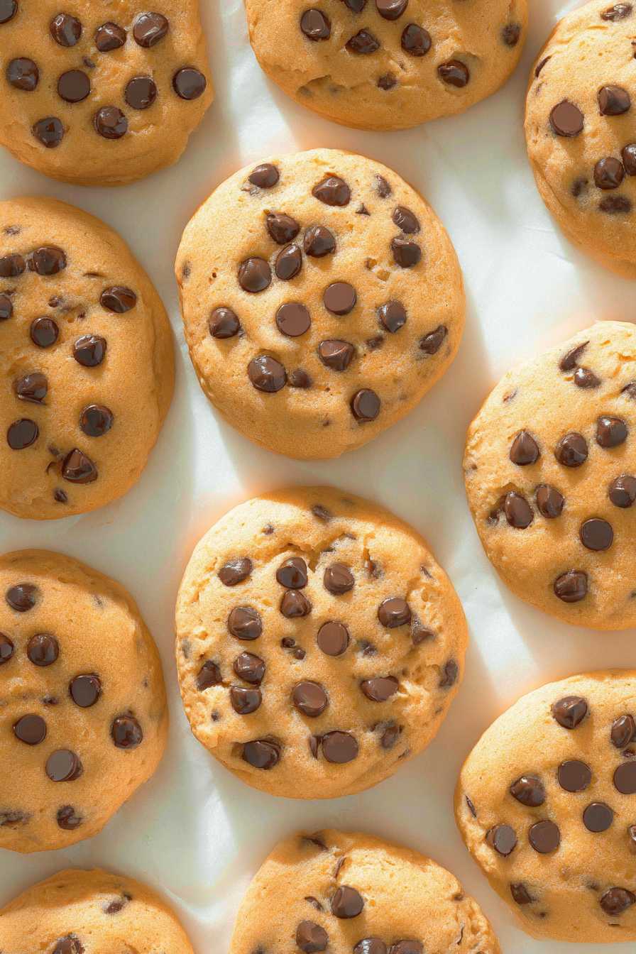 Home 10 Golden chocolate chip cookies on parchment paper, overhead view